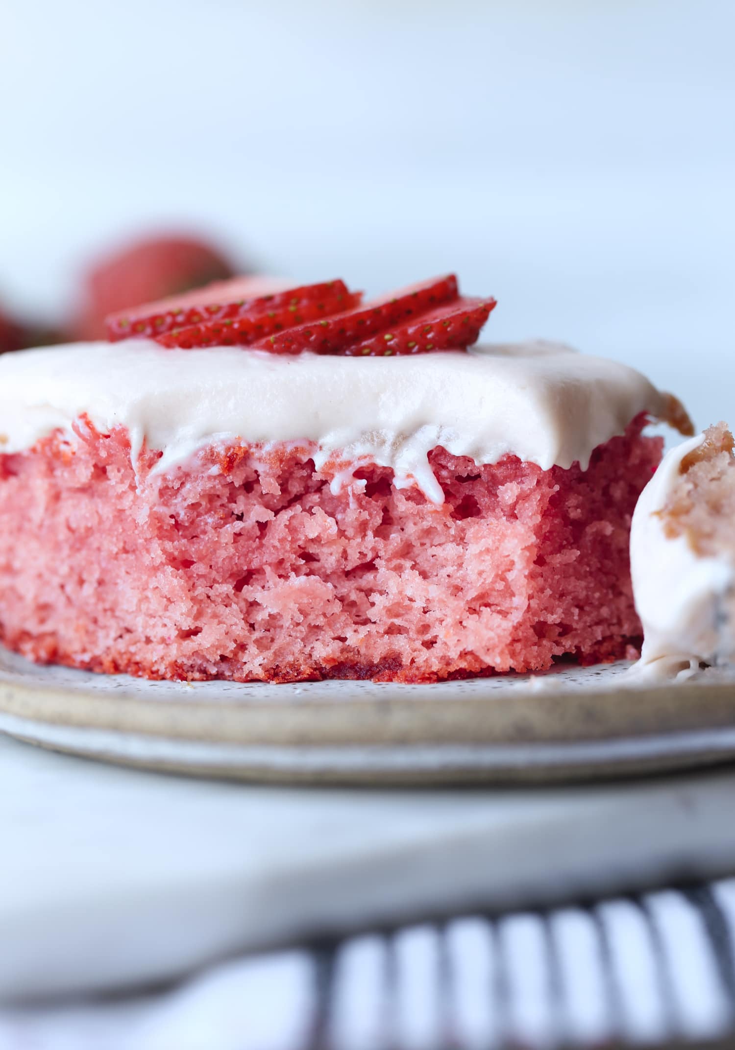 un trozo de tarta de fresa en un plato al que le falta un trozo