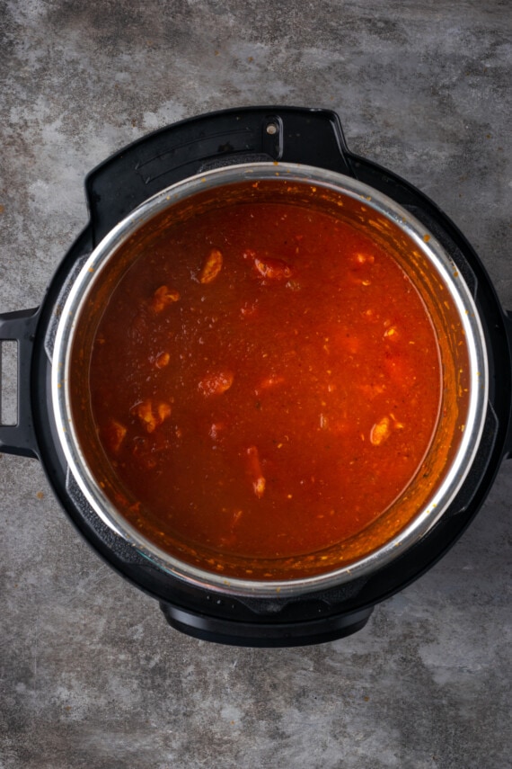 Pollo cocido en salsa de tomate dentro de la olla instantánea.