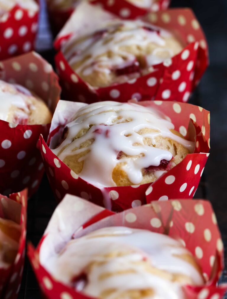 Muffins de suero de leche de fresa envueltos en envoltorios de muffins de lunares rojos y blancos.