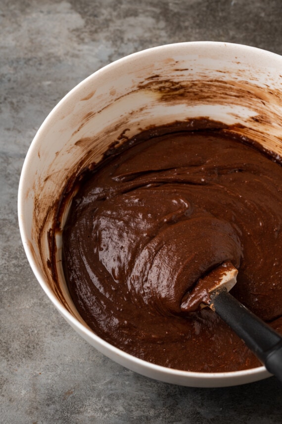 La masa de brownie en un tazón para mezclar con una espátula de goma.