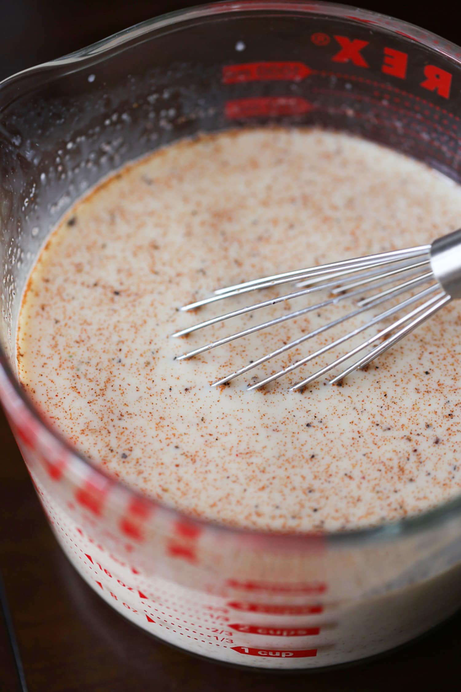 Leche batida y especias en una taza medidora