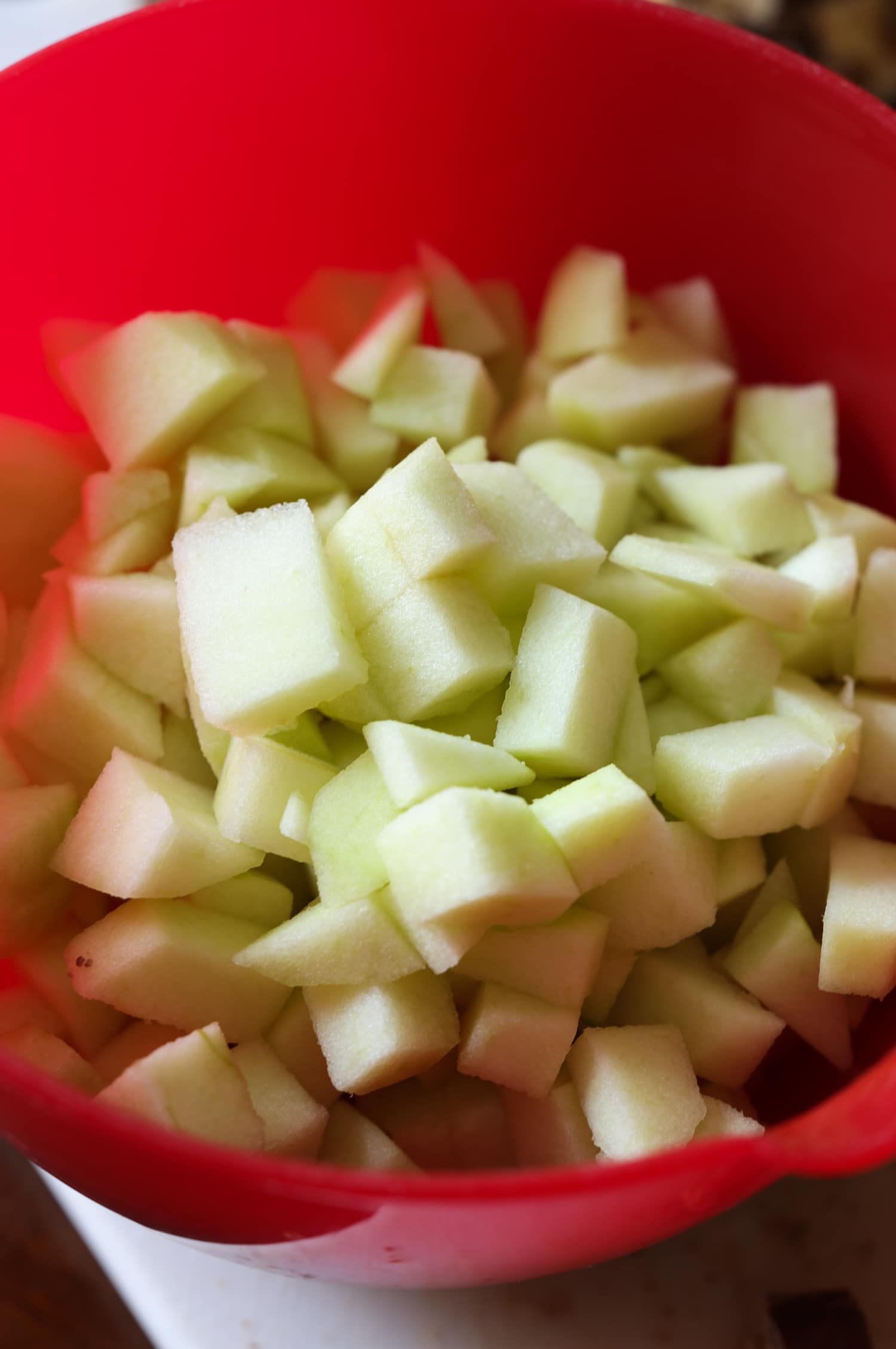 manzanas granny smith picadas en un tazón rojo