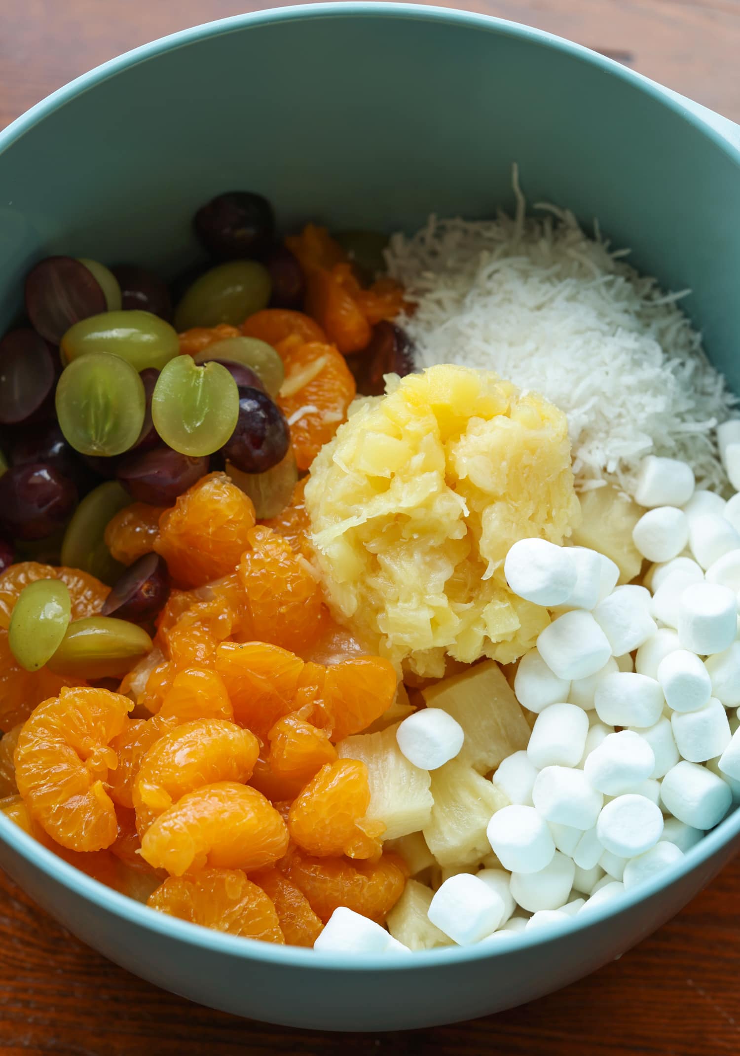 Frog Eye Salad es una ensalada dulce de verano con fruta, natillas, cobertura batida y pasta. ¡Es una delicia de textura y sabor, y es la receta de guarnición perfecta para su barbacoa de verano! un tazón para mezclar con mini malvaviscos, coco rallado, piña triturada, mandarinas y uvas.