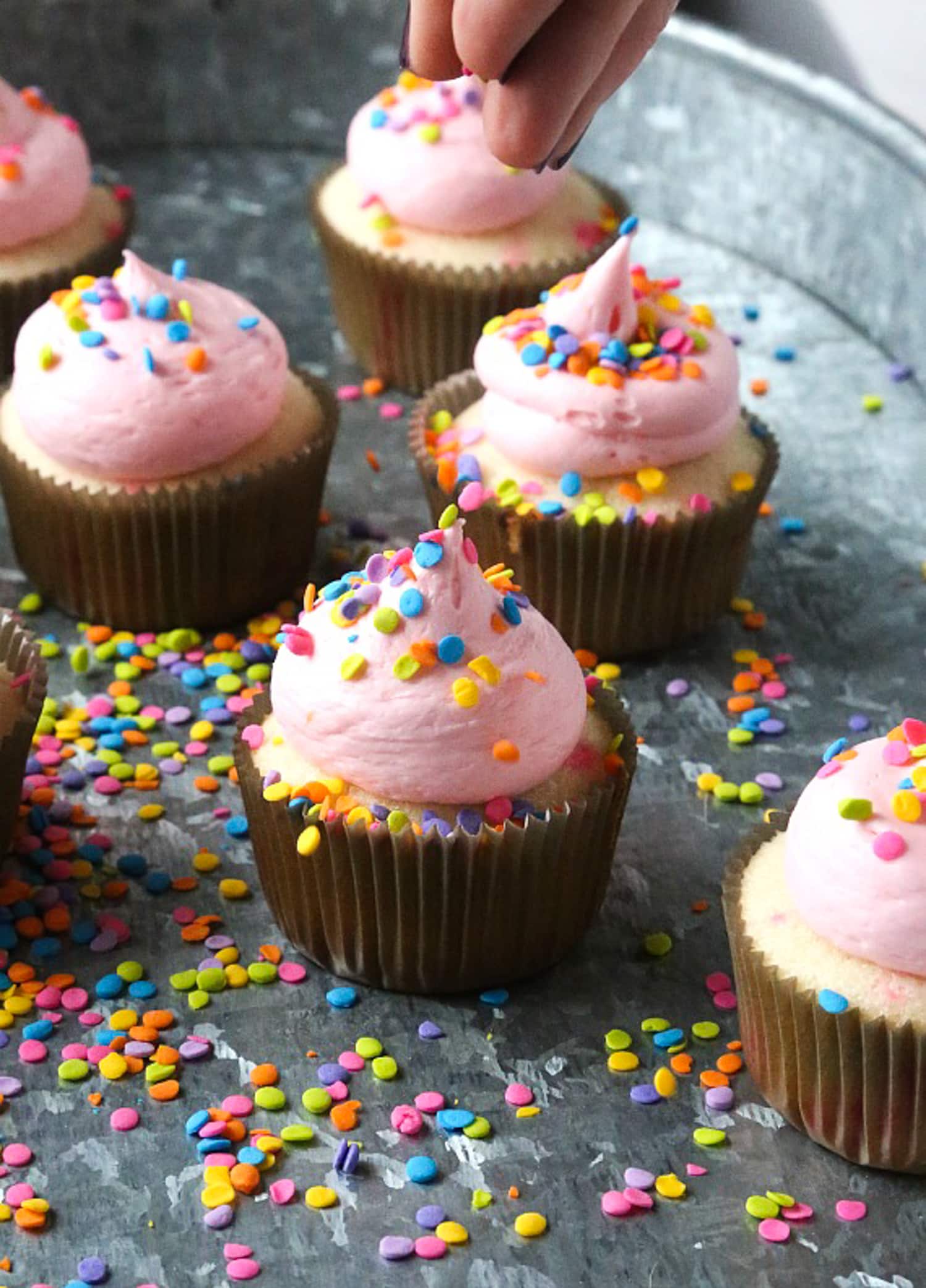 dejando caer chispas en un funfetti espolvorear cupckae con crema de mantequilla rosa