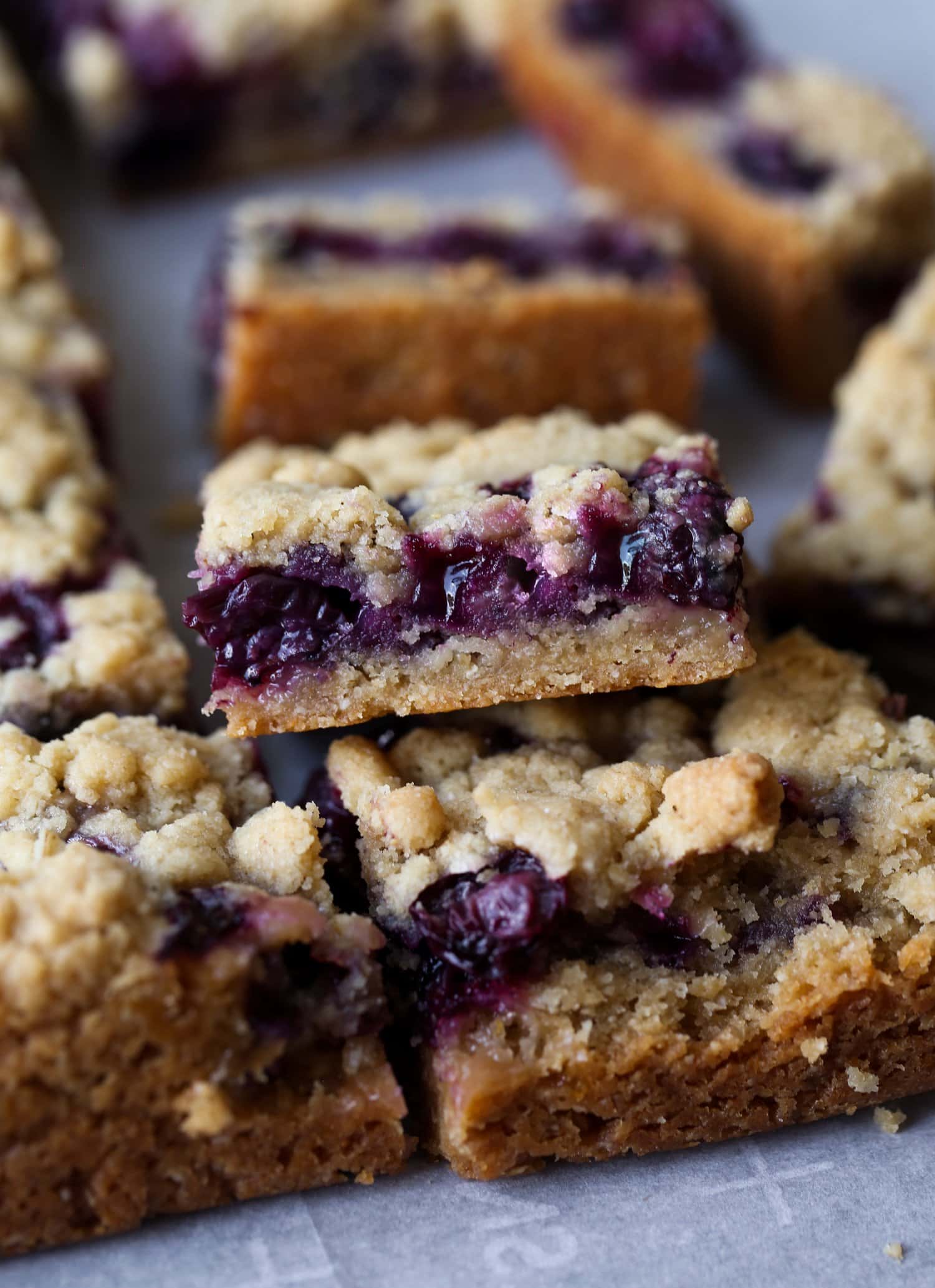 Las Blueberry Crumble Bars son mantecosas, dulces y están llenas de arándanos frescos y jugosos. ¡Estos son el postre de arándanos perfecto para el verano! Barras con corteza de pan dulce, relleno de arándanos y cubierta de migas cortadas y apiladas para mostrar el relleno