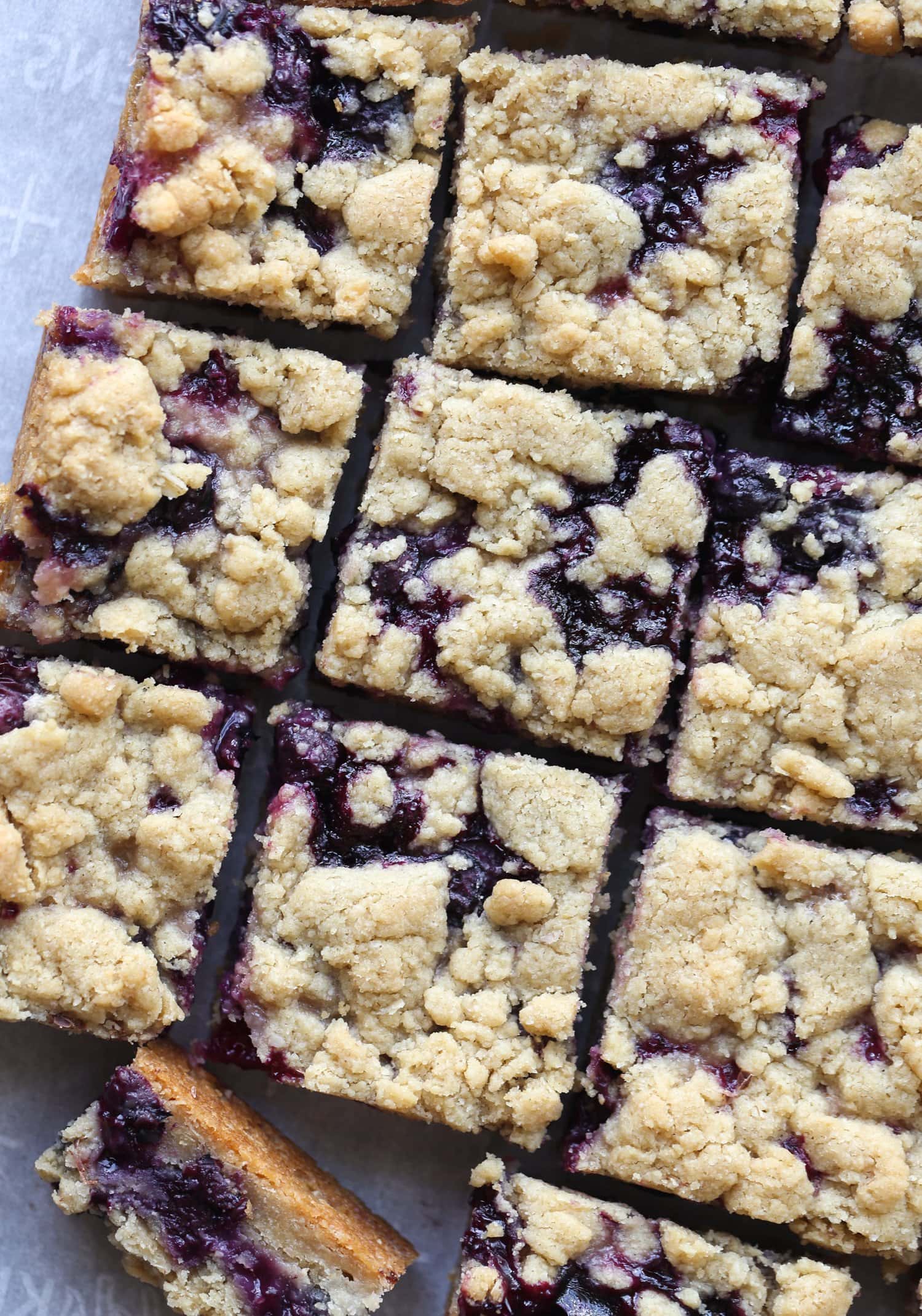 Las Blueberry Crumble Bars son mantecosas, dulces y están llenas de arándanos frescos y jugosos. ¡Estos son el postre de arándanos perfecto para el verano! Blueberry Crumble Bars cortado en cuadrados desde arriba