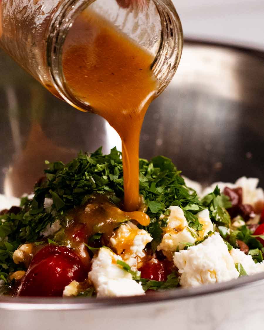 Verter el aderezo sobre la ensalada de garbanzos Antipasto