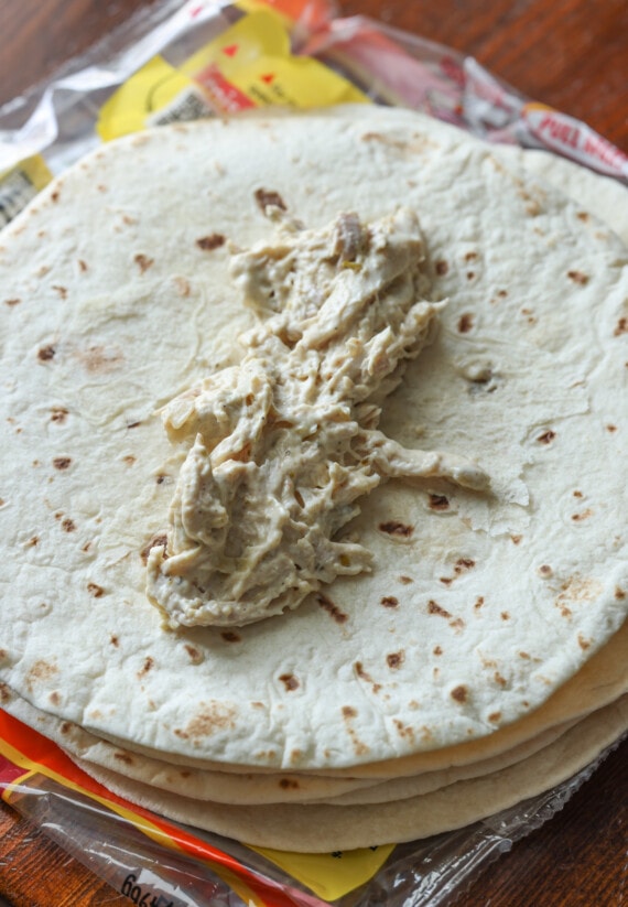 mezcla cremosa de pollo encima de una tortilla de harina antes de enrollarla
