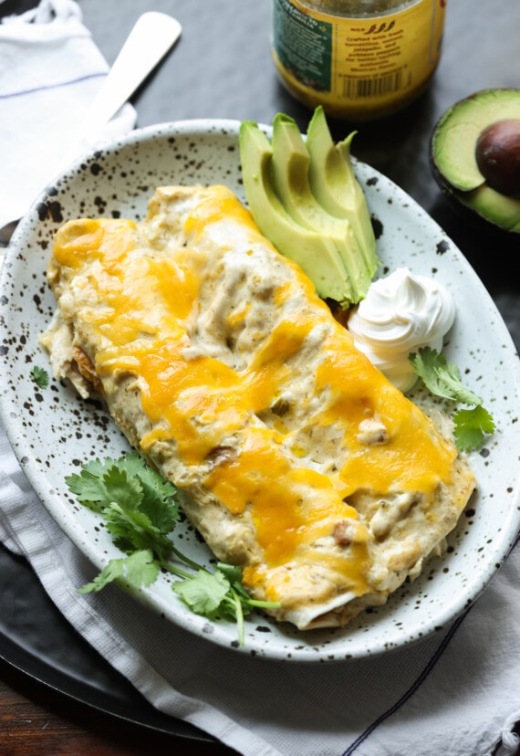 2 enchiladas de pollo en un plato de gres cubierto de queso