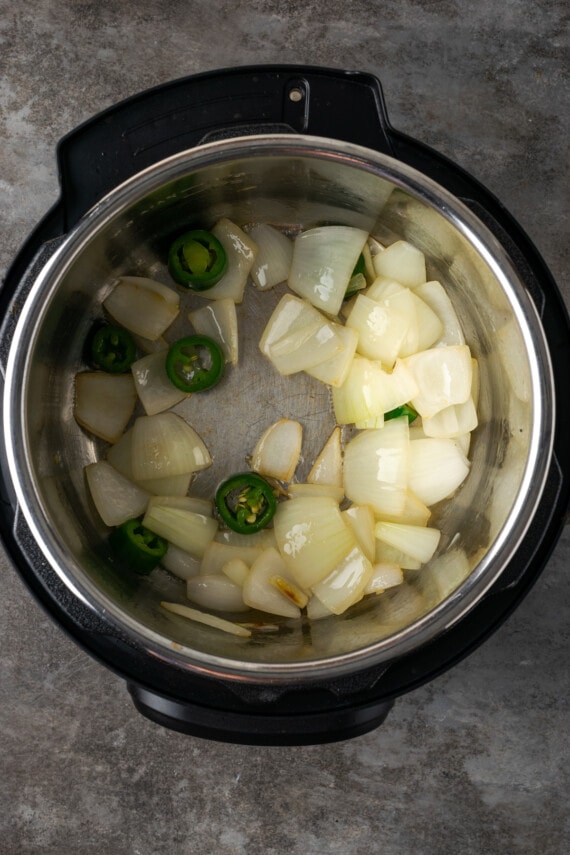 ¡Esta receta de Instant Pot Carnitas necesita solo 5 minutos de preparación! Haga carnitas increíblemente tiernas, jugosas y crujientes para tacos de cerdo y más. Cebollas picadas y jalapeños salteados dentro de la olla instantánea.