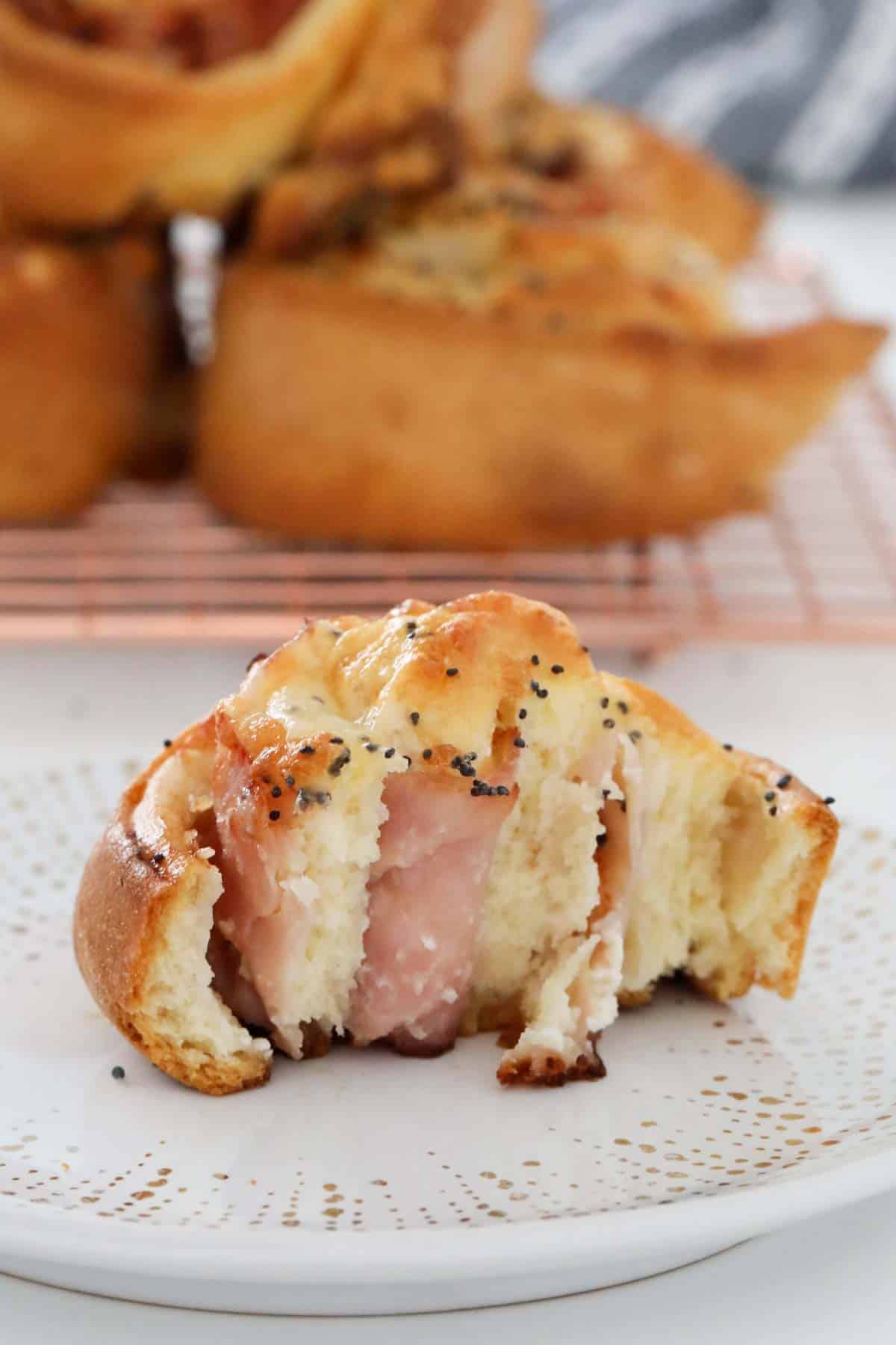 Un rollo salado medio comido con jamón y queso.