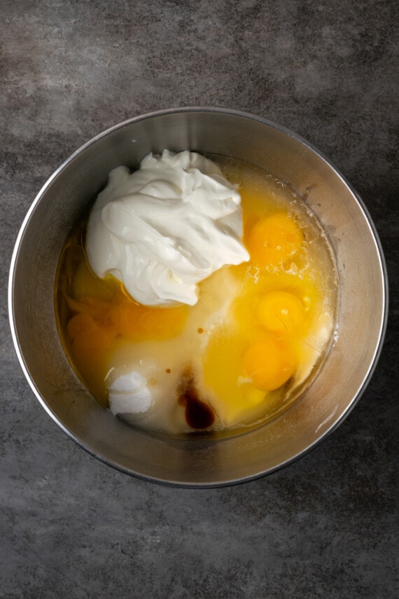 Los ingredientes para el pastel de crema agria combinados en un tazón de mezcla de metal.