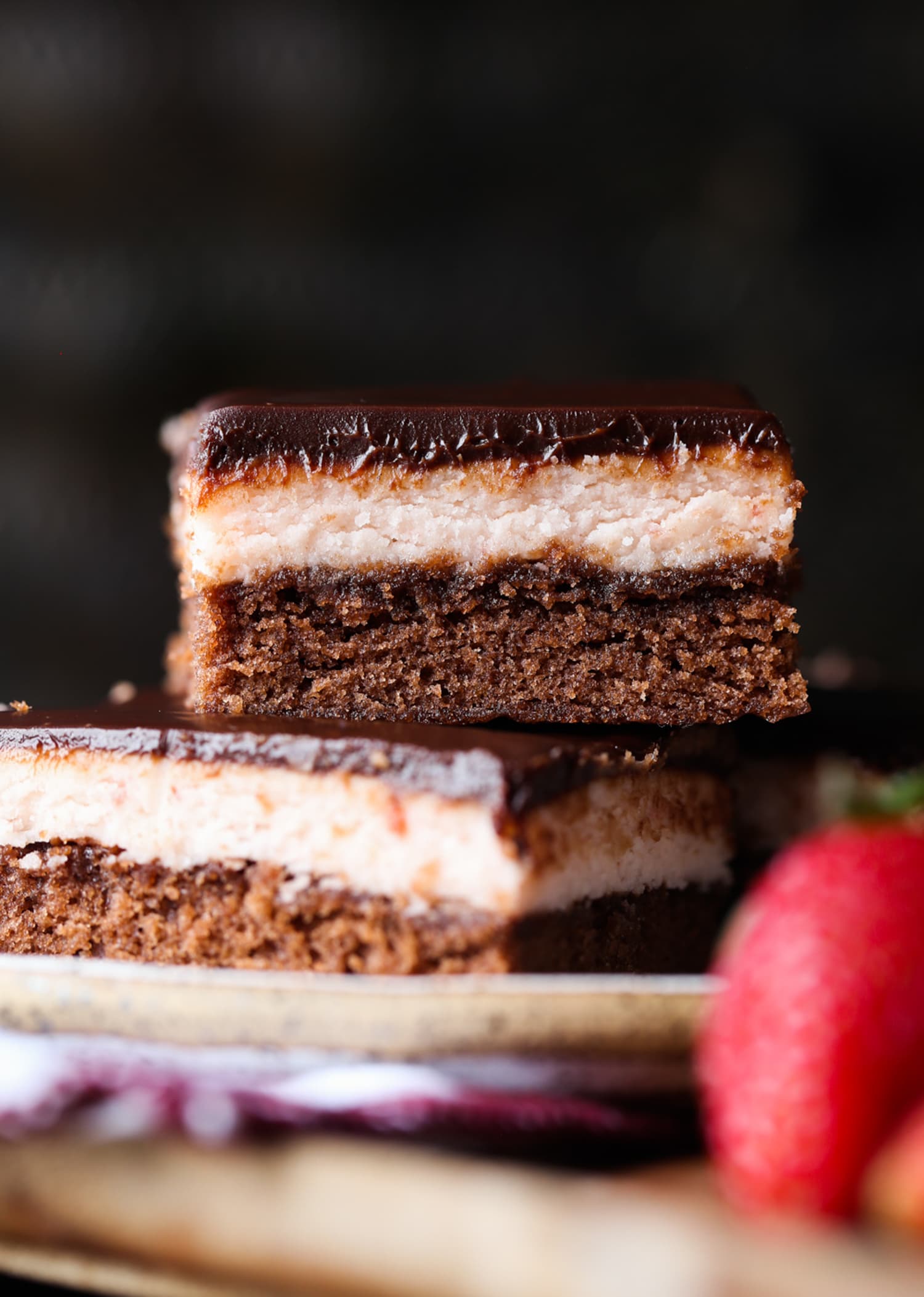 Brownies de chocolate de tres capas cubiertos con glaseado de fresa y ganache de chocolate apilados