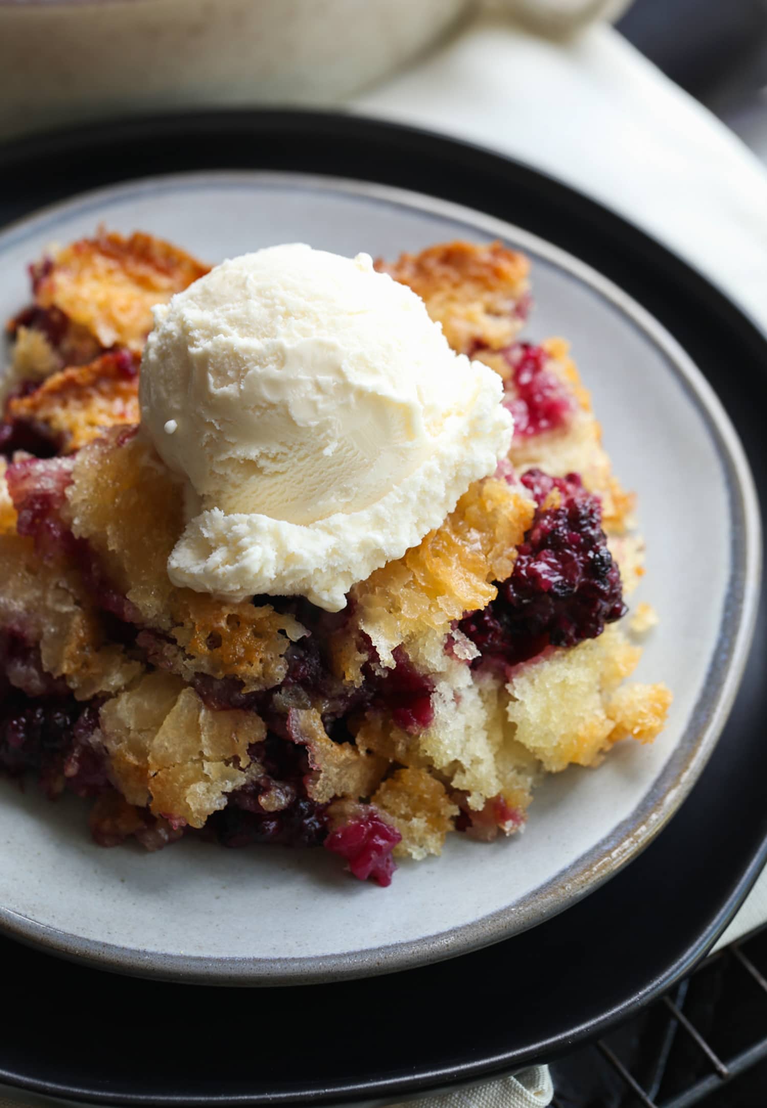 Zapatero de moras en un plato con helado de vainilla