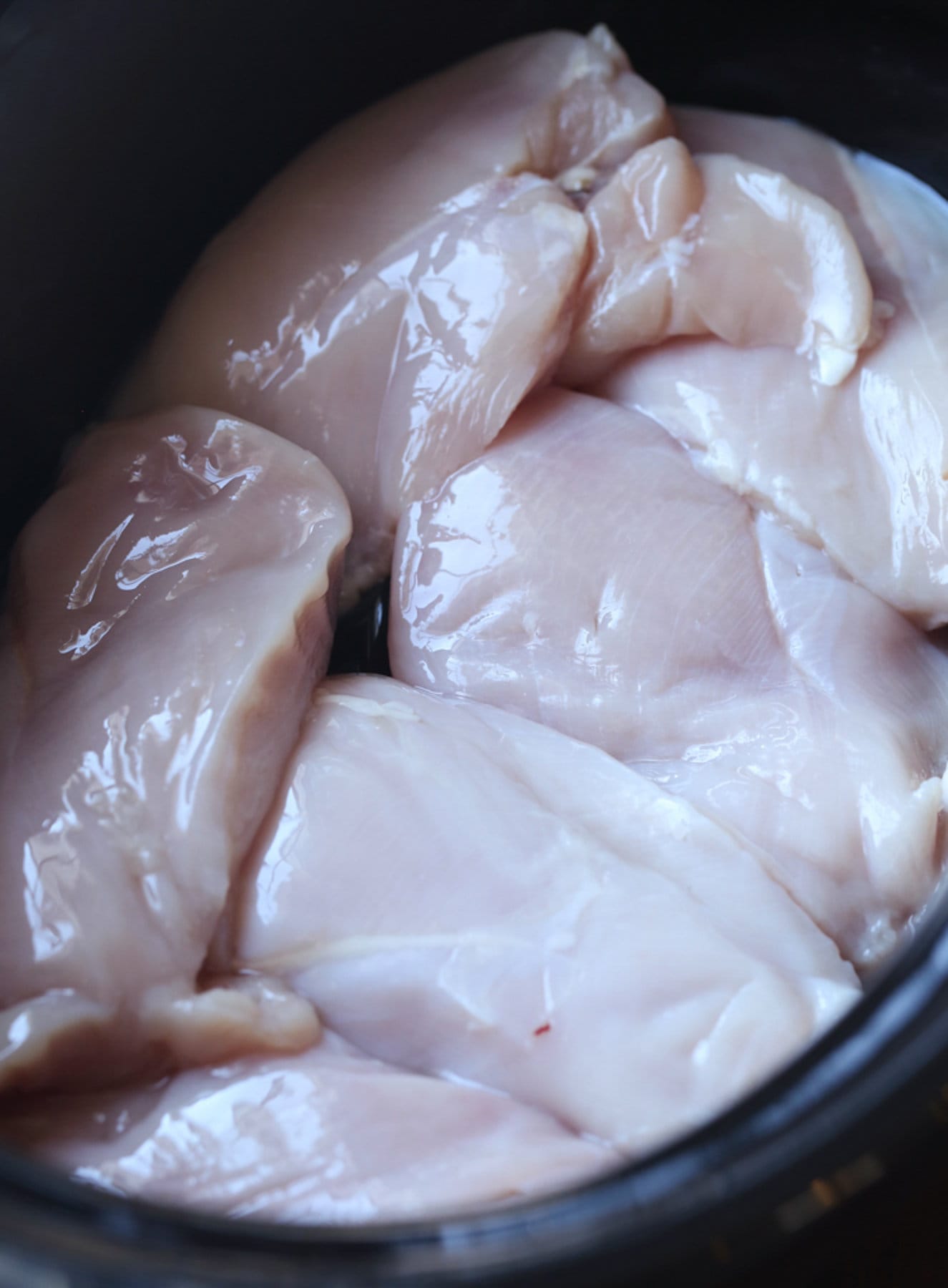 pechugas de pollo crudas en una olla de barro