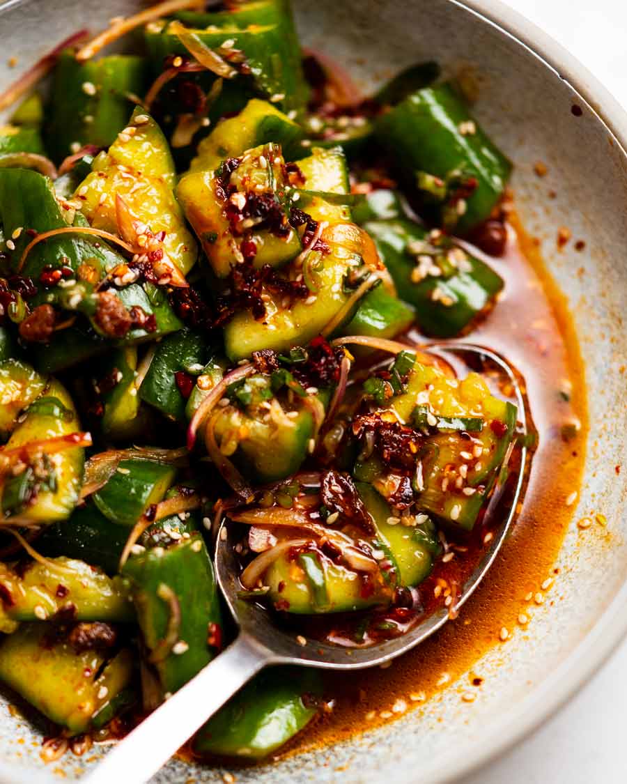 Comer ensalada picante de pepino con cuchara