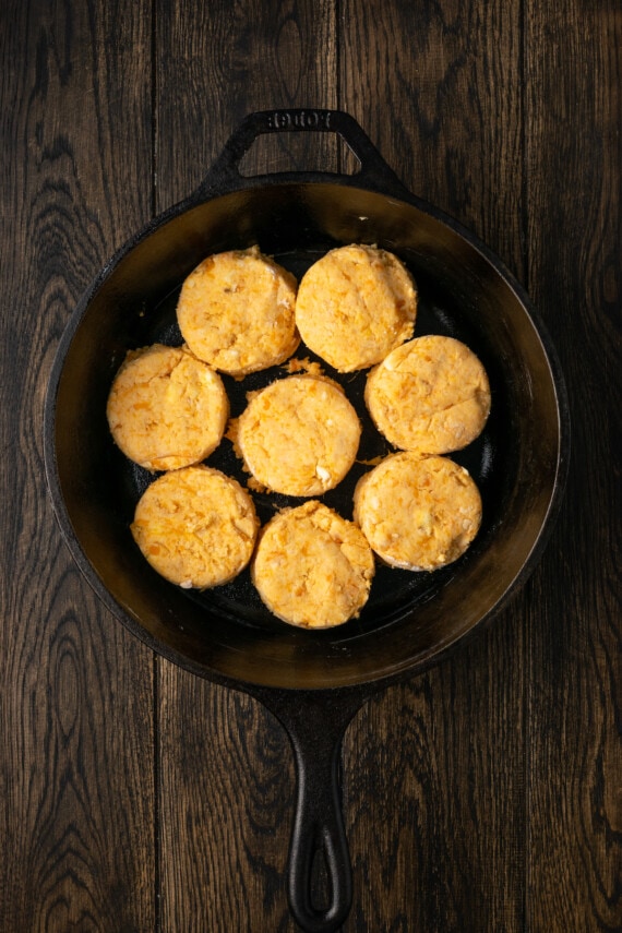 Ocho galletas de camote cortadas dentro de una sartén de hierro fundido.
