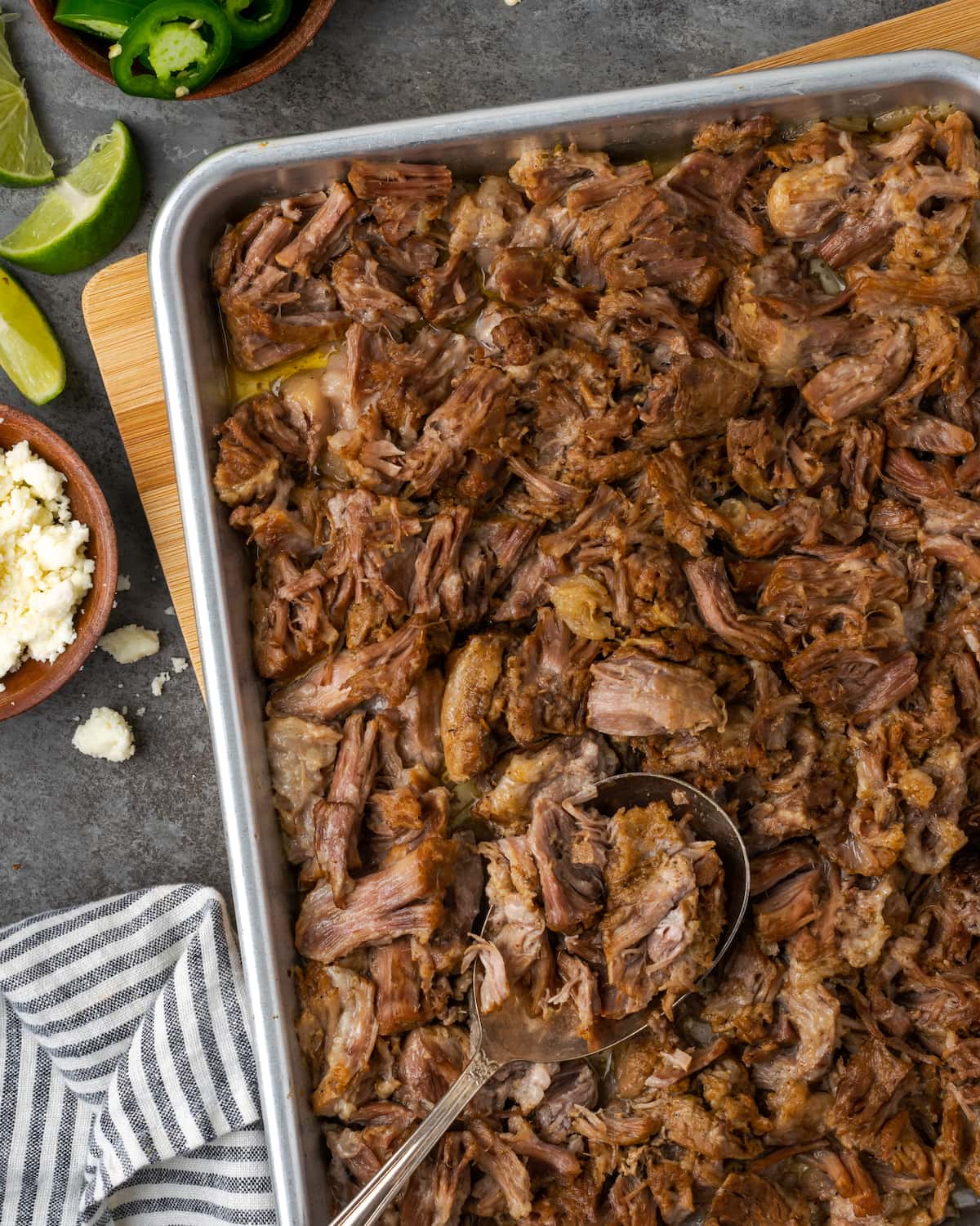 ¡Esta receta de Instant Pot Carnitas necesita solo 5 minutos de preparación! Haga carnitas increíblemente tiernas, jugosas y crujientes para tacos de cerdo y más. Vista aérea de carnitas instantáneas en una bandeja para hornear de metal.