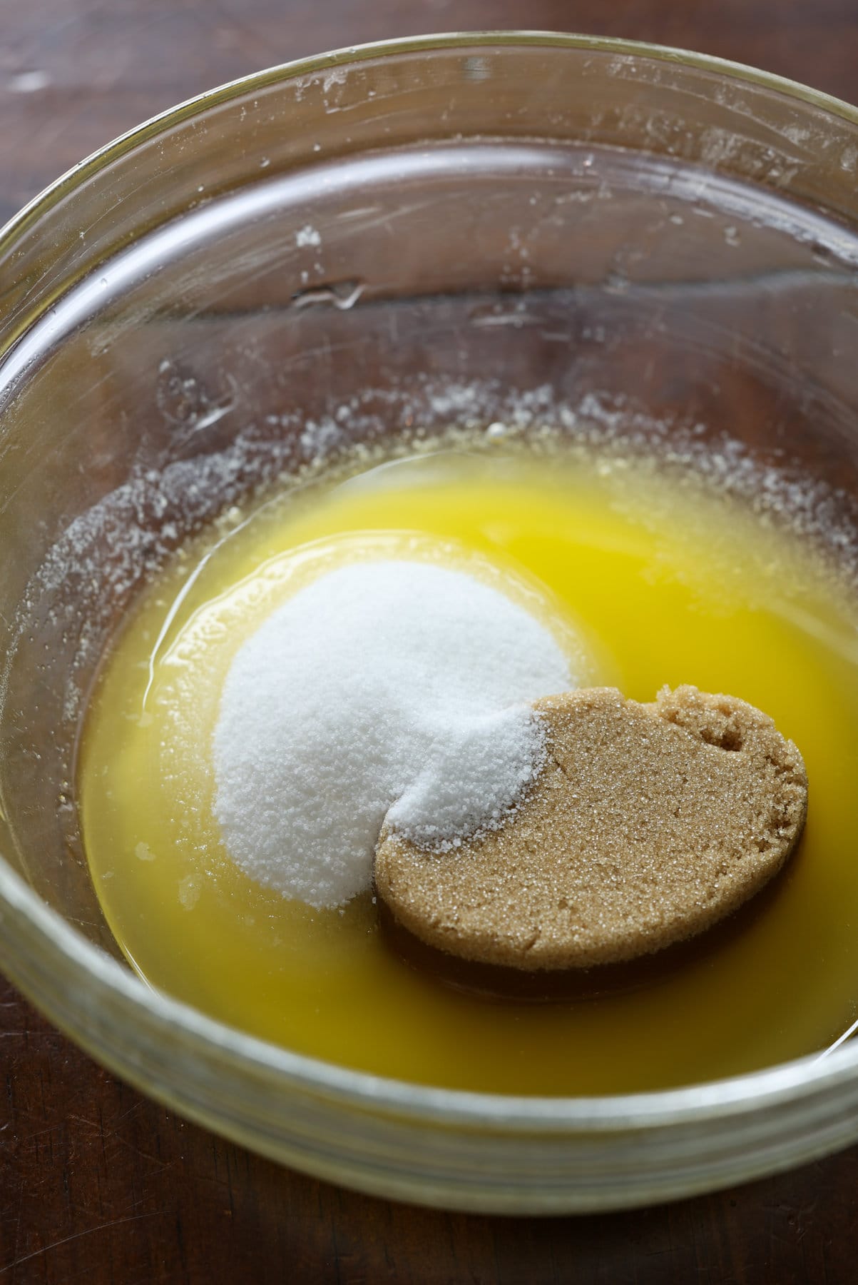 Streusel Topping, también conocido como Crumb Topping, es muy fácil de hacer y se puede usar en muchos productos horneados diferentes, desde muffins y panes hasta pasteles y tartas, ¡o se hornea solo y se usa como una cobertura crujiente de mantequilla! mantequilla derretida, azúcar granulada y azúcar moreno claro en un recipiente de vidrio transparente