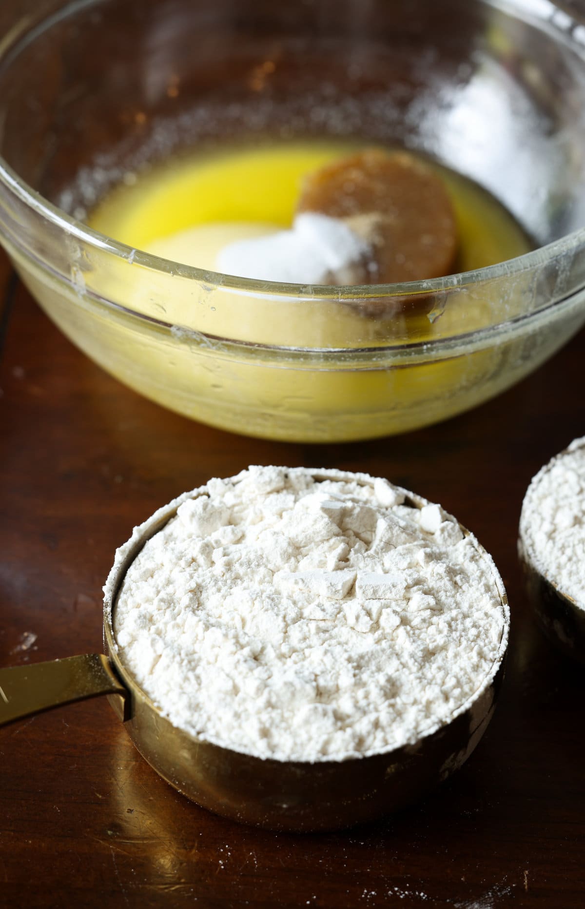 Streusel Topping, también conocido como Crumb Topping, es muy fácil de hacer y se puede usar en muchos productos horneados diferentes, desde muffins y panes hasta pasteles y tartas, ¡o se hornea solo y se usa como una cobertura crujiente de mantequilla! harina para todo uso en una taza medidora frente a un tazón de mantequilla derretida y azúcar.
