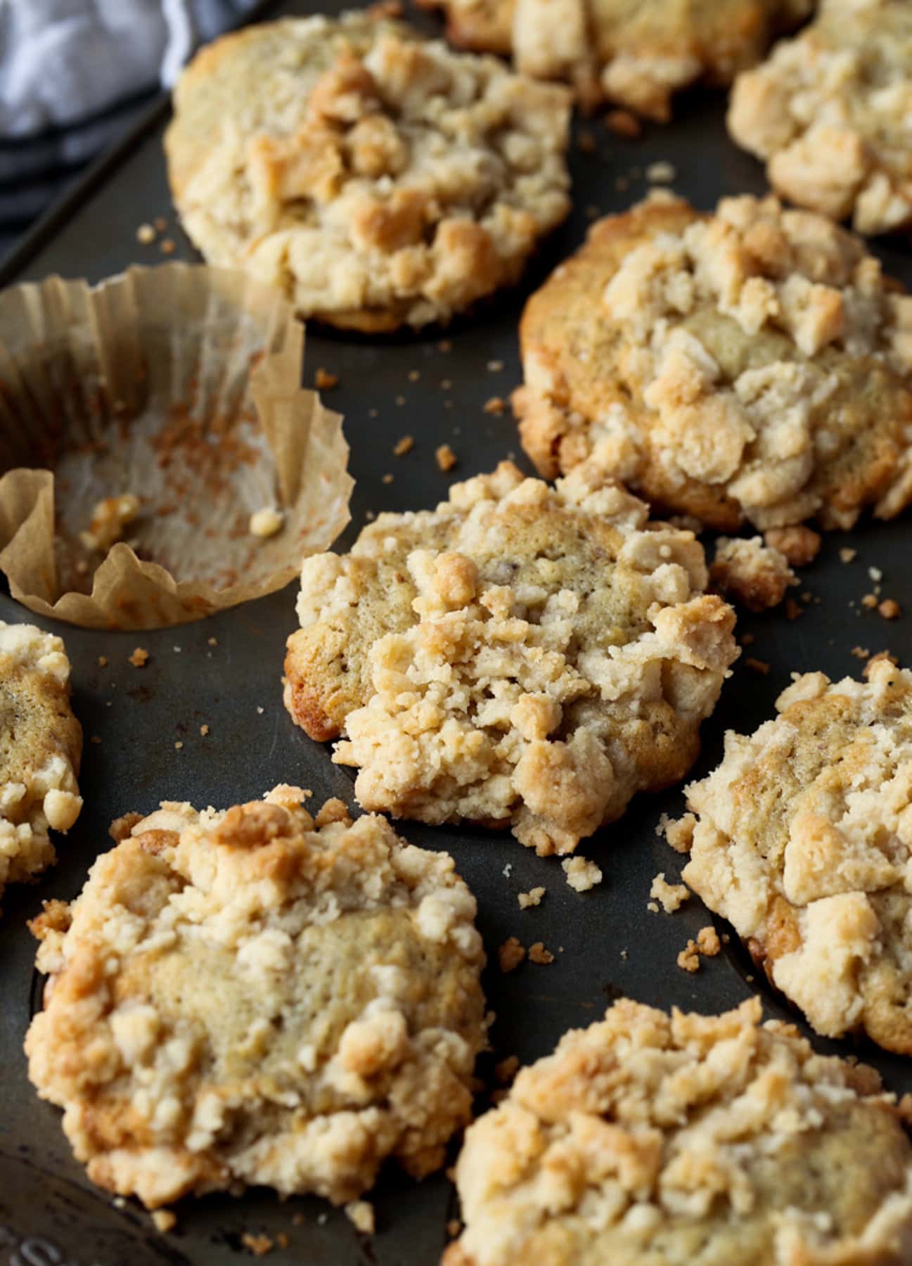Muffins de plátano con cobertura de migas en un molde para muffins con una capa vacía