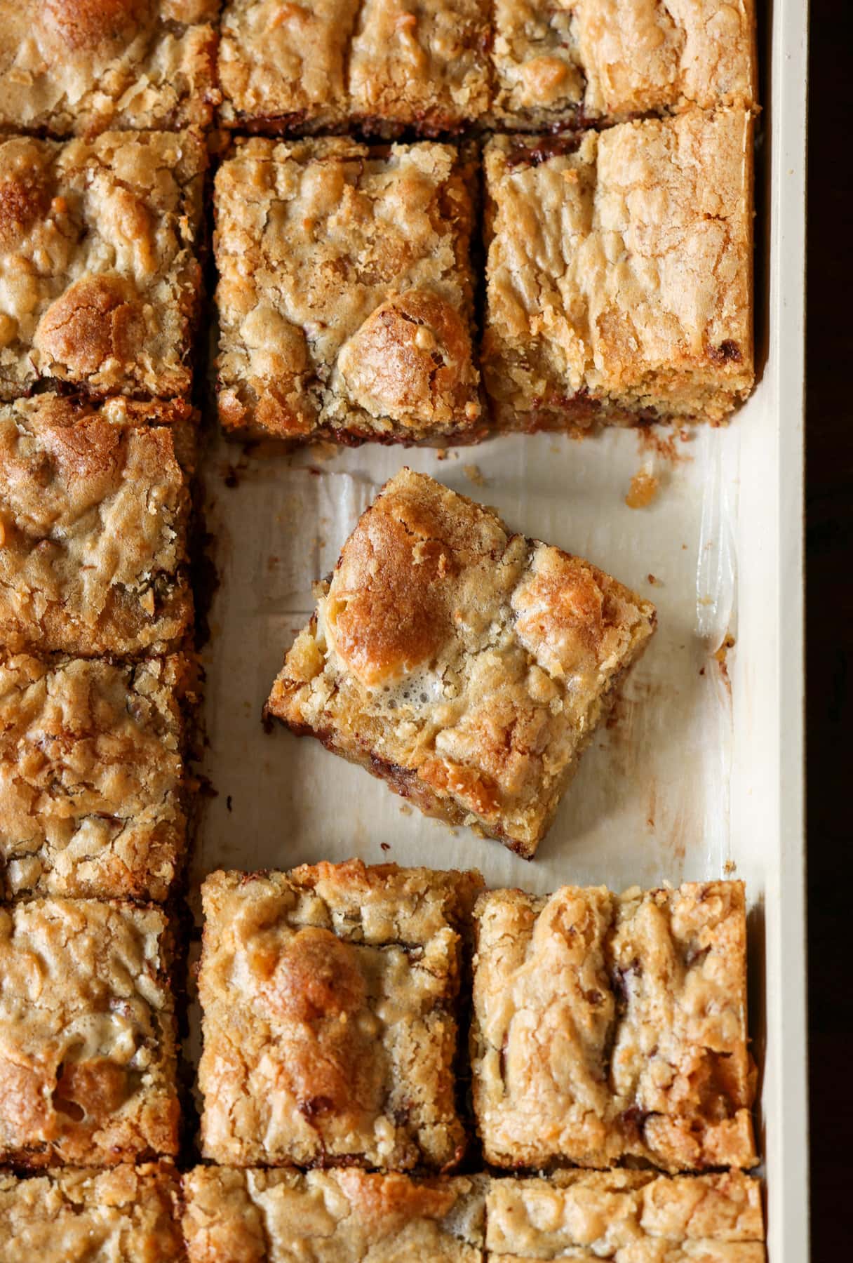 Mi Receta Blondie es la perfección. Barras de galletas masticables y mantecosas tachonadas con chispas de chocolate y mezcladas con coco dulce. Corta los blondies en un molde para hornear forrado con papel pergamino.