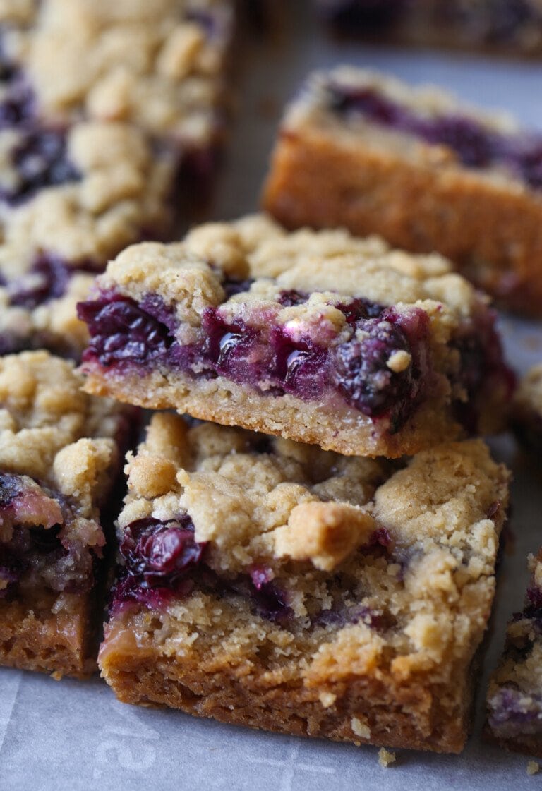 Primer plano de Blueberry Crumb Bars apilados en una encimera.