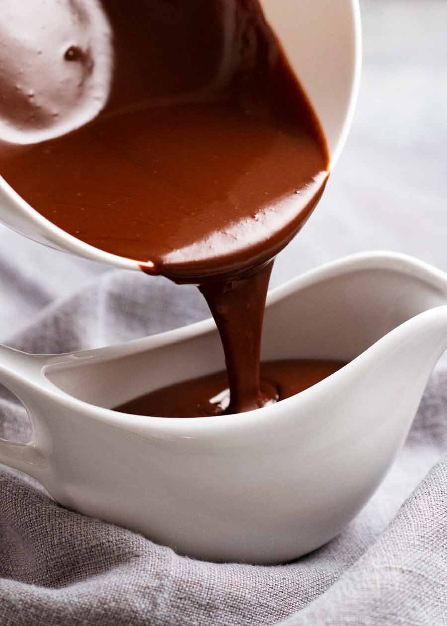 Verter salsa de chocolate en una jarra para pastel de chocolate caliente