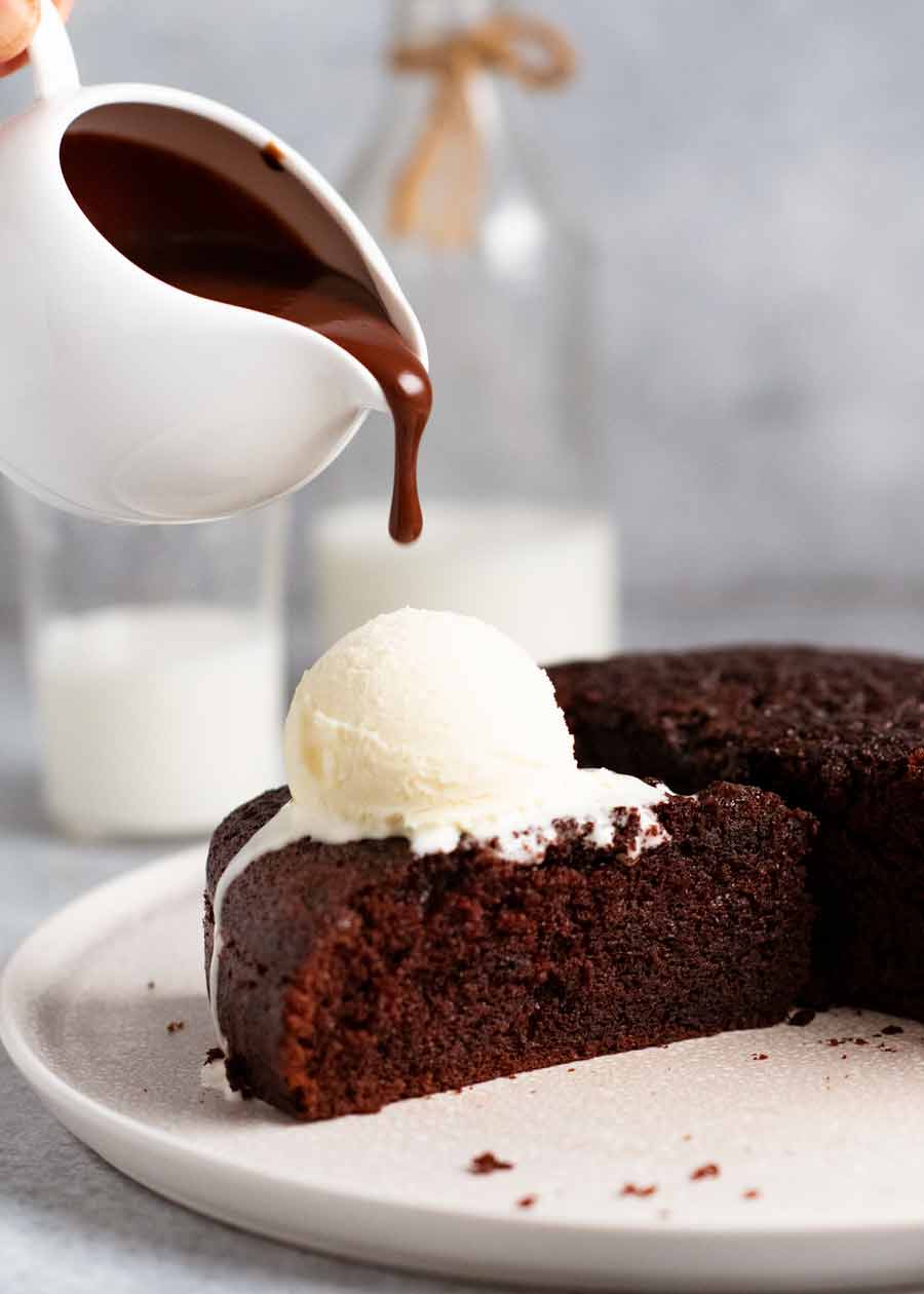Verter salsa sobre pastel de chocolate caliente
