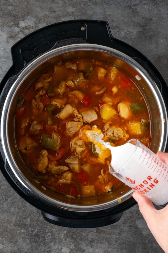 Instant Pot Hawaiian Chicken es una cena fácil de una olla cocinada con piña jugosa, pimientos y cebollas en una salsa dulce y picante. Se vierte una lechada de maicena en pollo hawaiano en Instant Pot.