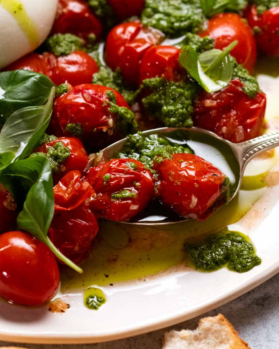 Primer plano de jugosos tomates asados ​​en ensalada burrata de tomate Burst
