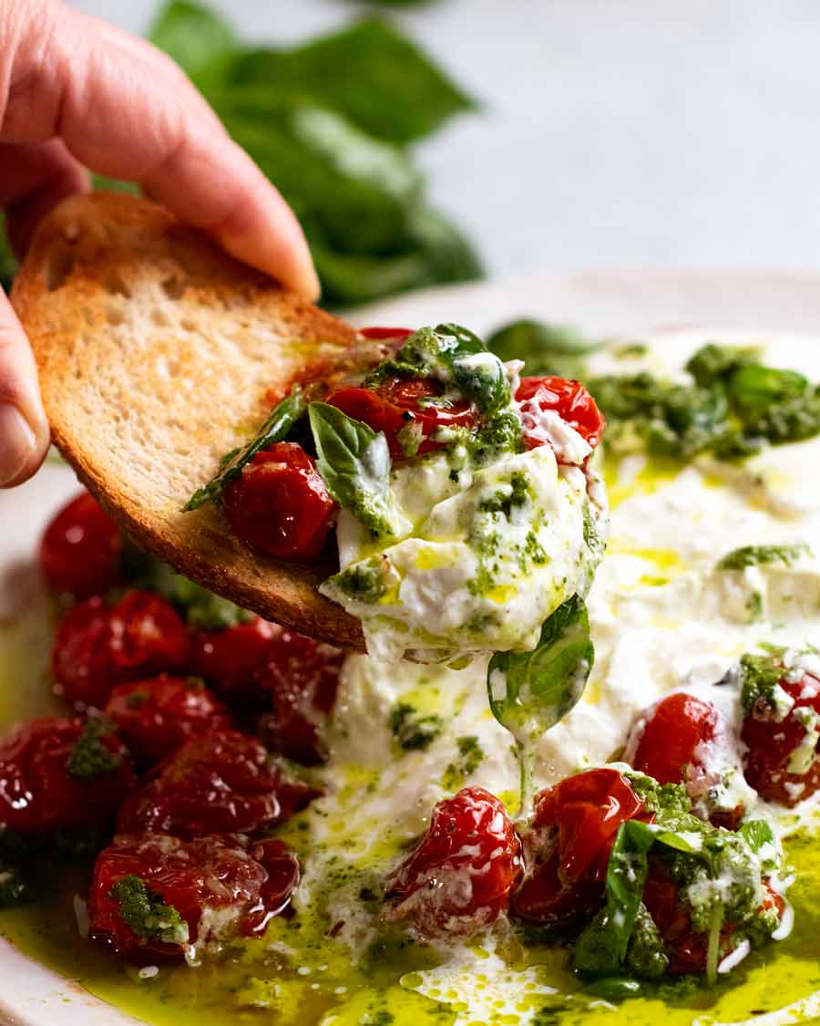 Recogiendo ensalada burrata de tomate Burst con pan crujiente