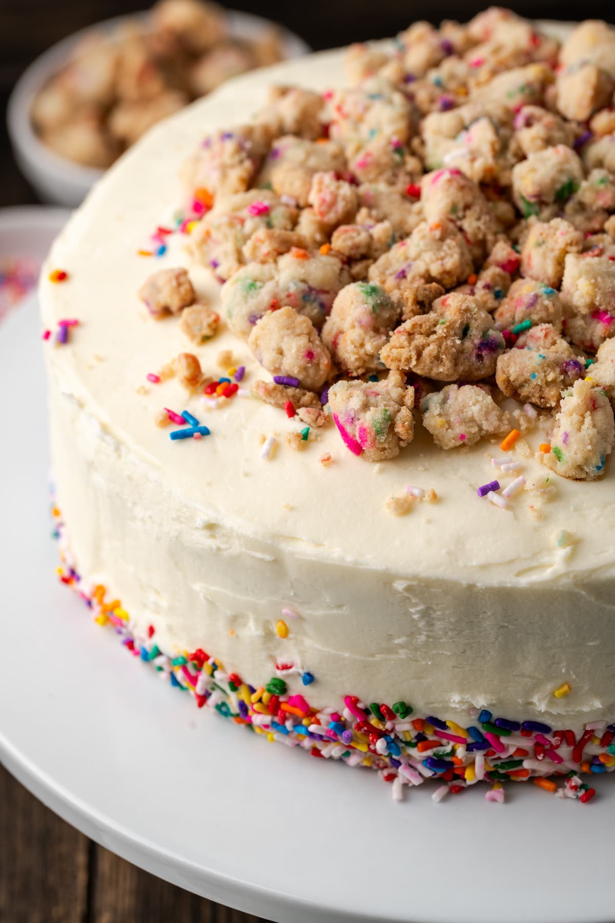 This is the best confetti cake recipe made from fluffy white cake loaded with rainbow sprinkles. Even better than a boxed Funfetti cake mix! Frosted confetti cake decorated with sprinkles and a crumbled funfetti streusel topping.