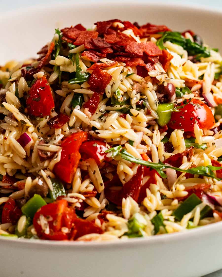 Montón de ensalada italiana de risoni/orzo con trocitos de salami crujiente