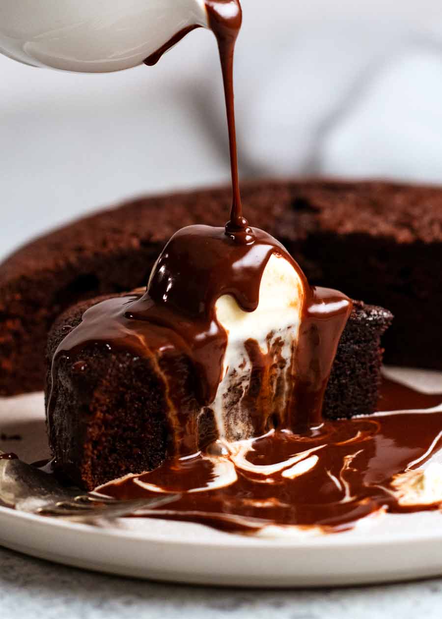 Verter salsa de chocolate sobre pastel de chocolate caliente