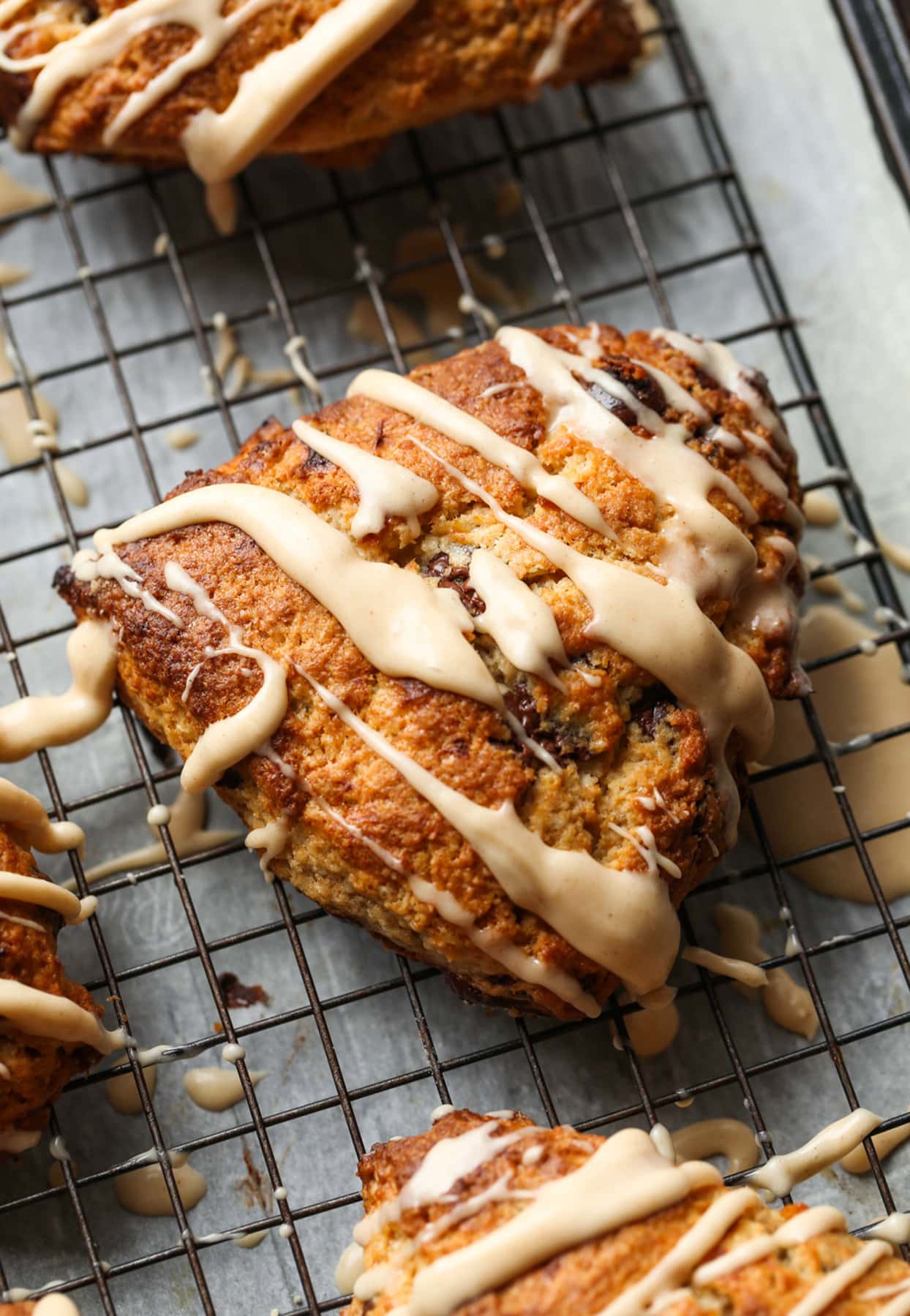 These Chocolate Chip Banana Scones have perfectly crisp, buttery edges with a fluffy, yet flaky, soft center making this the perfect scone recipe! Chocolate Chip Banana Scone with icing drizzled on top
