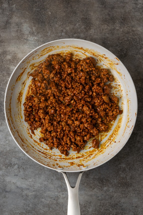 Make satisfying crunch wraps loaded with taco meat, melty cheese, tostada, sour cream, and more wrapped up inside a toasty flour tortilla! Cooked seasoned ground beef in a skillet.