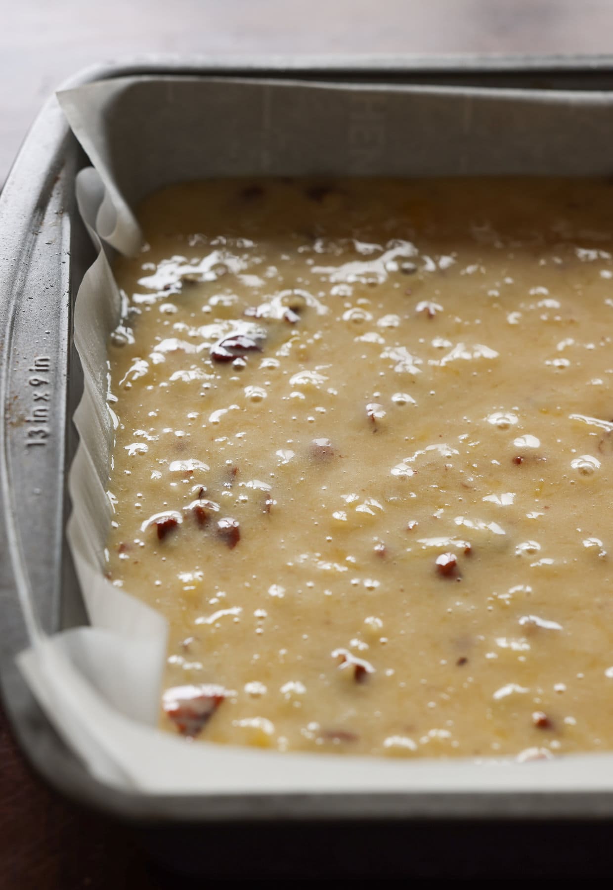 Cake batter with walnuts in a 9x13 cake pan before going into the oven.
