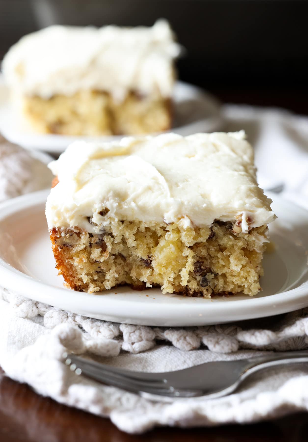 Spreading cream cheese icing onto a cake with an offset spatula