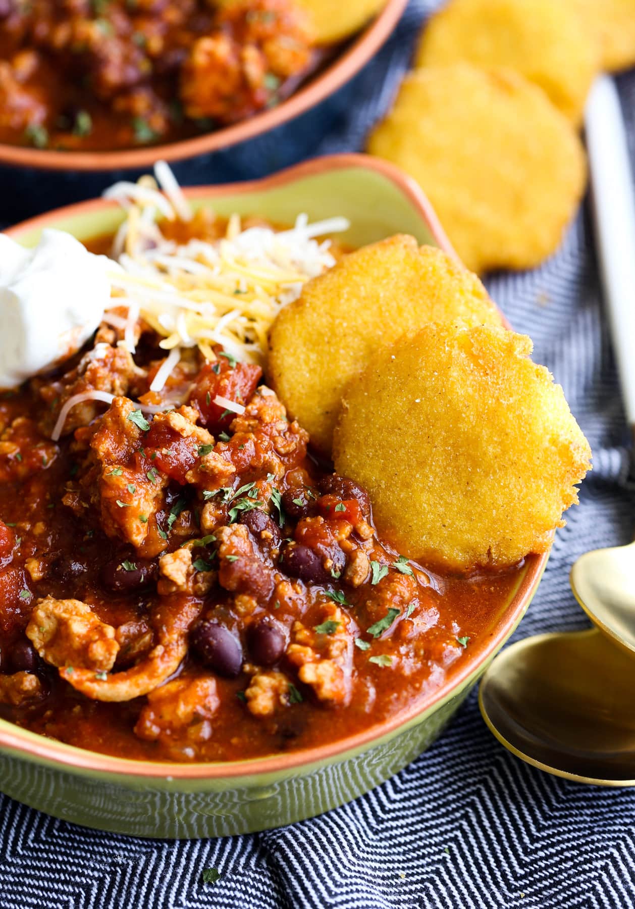 Crispy on the outside and soft on the inside, hot water cornbread is easy to make and totally crave-worthy. This is a simple recipe for fried cornbread that you can serve with all of your favorite Southern-style meals! a bowl of chili with hot water cornbread on the side