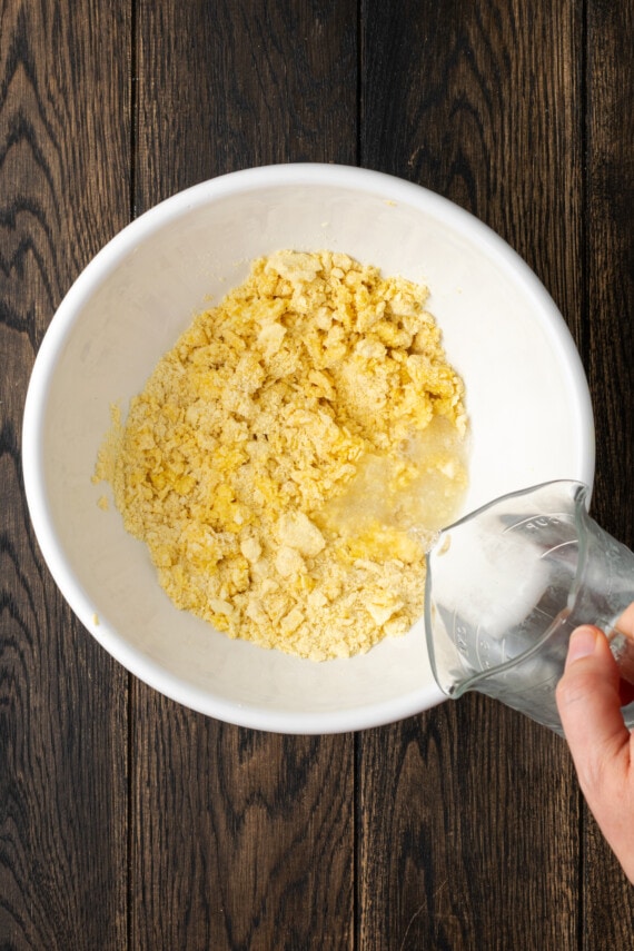 Crispy hot water cornbread is totally crave-worthy! Fried cornbread is an easy side dish to pair with your favorite Southern meals. Hot water is poured into a mixing bowl with cornbread ingredients.