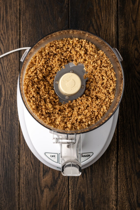 Crushed pecans inside a food processor.