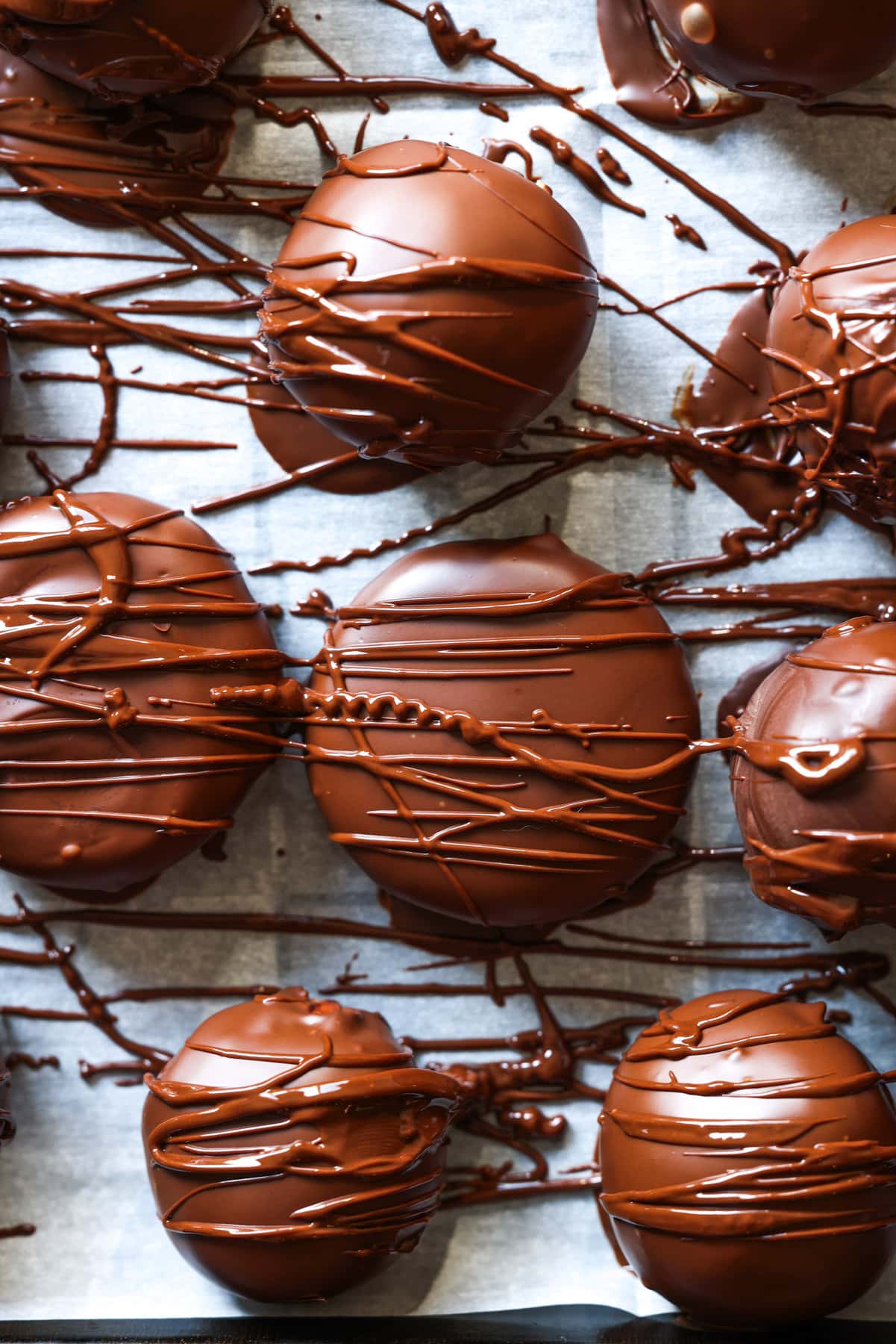 peanut butter patties coated in melted chocolate and drizzled with more melted chocolate