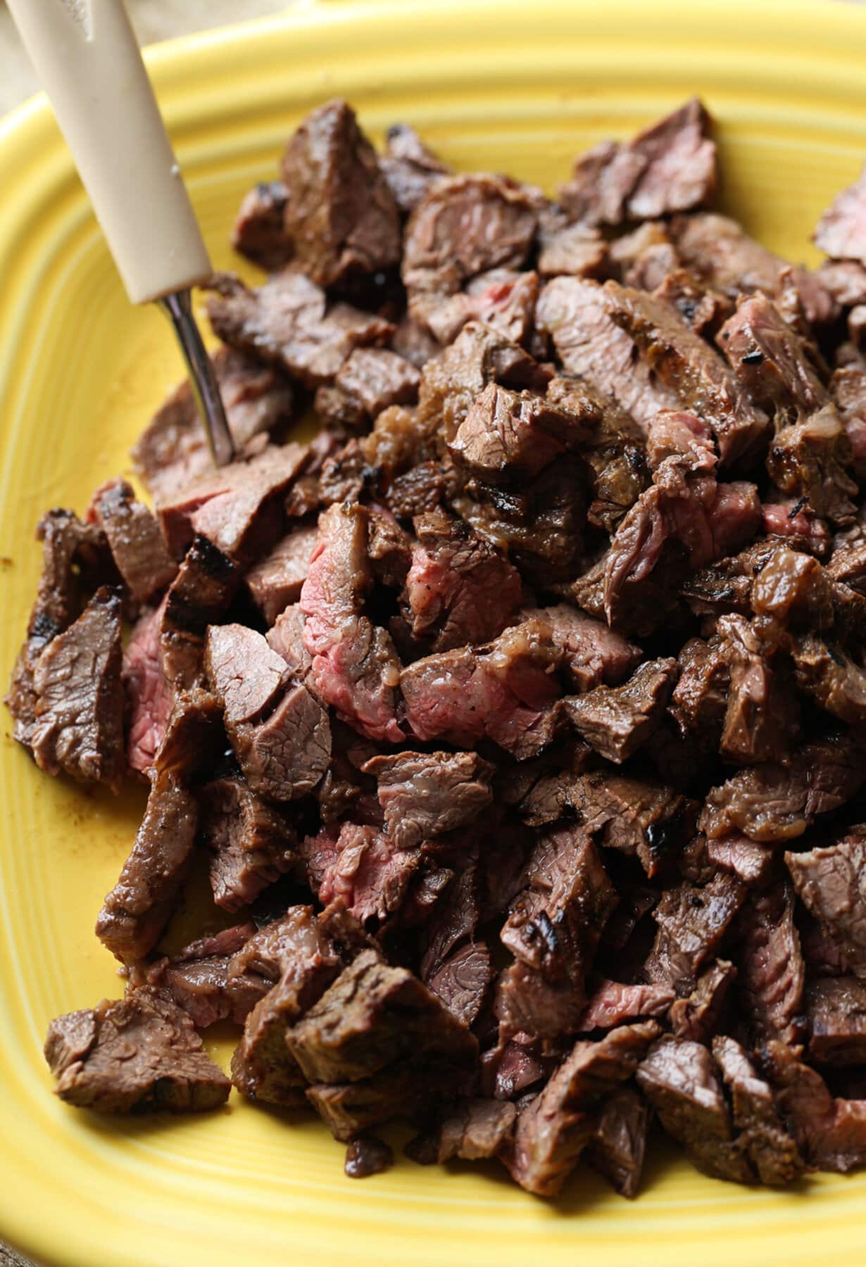 Carne Asada Fries Are a Tex Mex spin on loaded french fries. Marinated, grilled carne asada is sliced and served on top of seasoned fries with a cheesy sauce and tons of toppings of your choice! Grilled Carne Asada