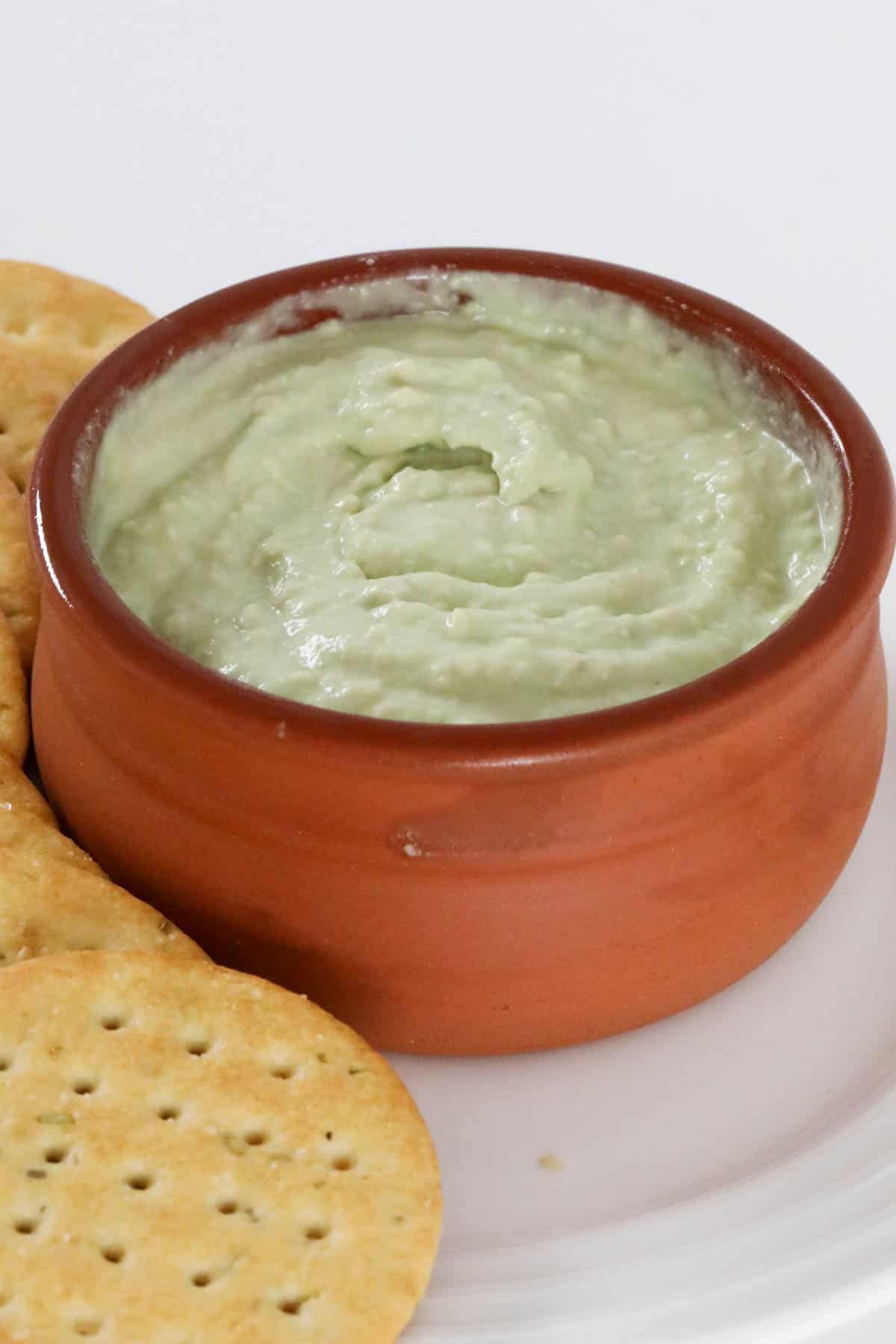 A ramekin filled with creamy avocado dip.