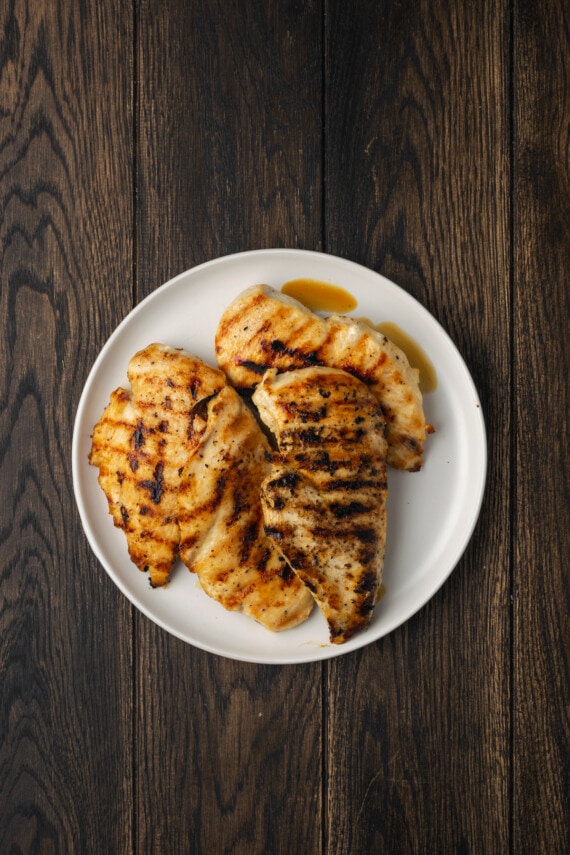 Creamy Buffalo Wild Wings Garlic Parmesan Chicken Pasta is a quick and easy dinner idea packed with bold flavor. Made with only 6 ingredients! Overhead view of two grilled chicken breasts on a plate.