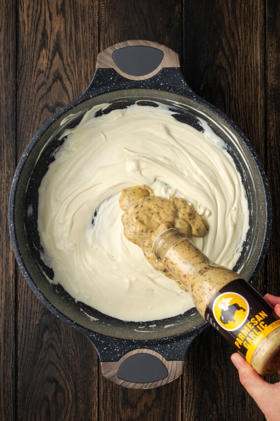 Creamy Buffalo Wild Wings Garlic Parmesan Chicken Pasta is a quick and easy dinner idea packed with bold flavor. Made with only 6 ingredients! Buffalo wing sauce added to a skillet with melted cream cheese.