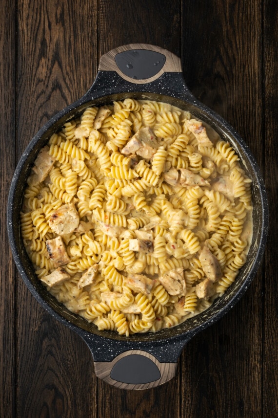 Creamy Buffalo Wild Wings Garlic Parmesan Chicken Pasta is a quick and easy dinner idea packed with bold flavor. Made with only 6 ingredients! Buffalo Wild Wings garlic parmesan chicken pasta in a skillet.