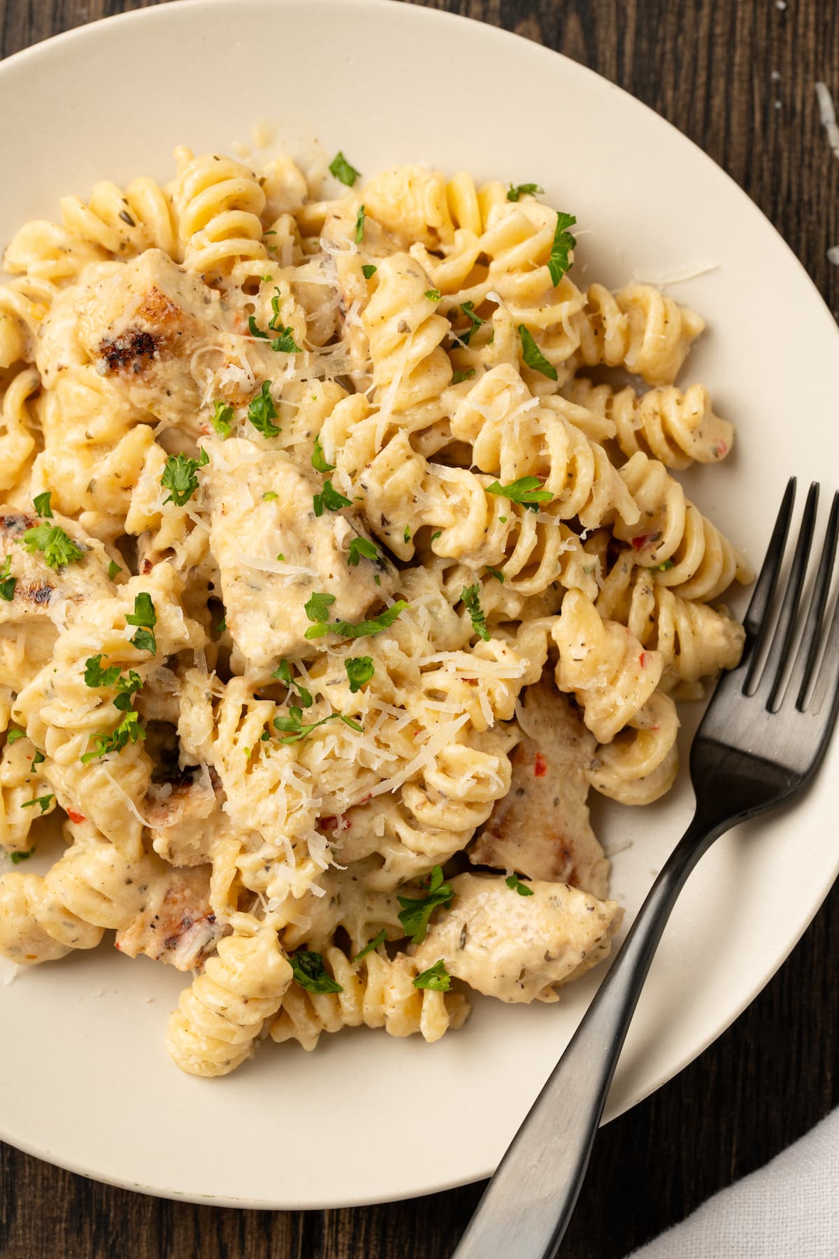 Creamy Buffalo Wild Wings Garlic Parmesan Chicken Pasta is a quick and easy dinner idea packed with bold flavor. Made with only 6 ingredients! Overhead view of a bowl of Buffalo Wild Wings garlic parmesan chicken pasta with a fork.