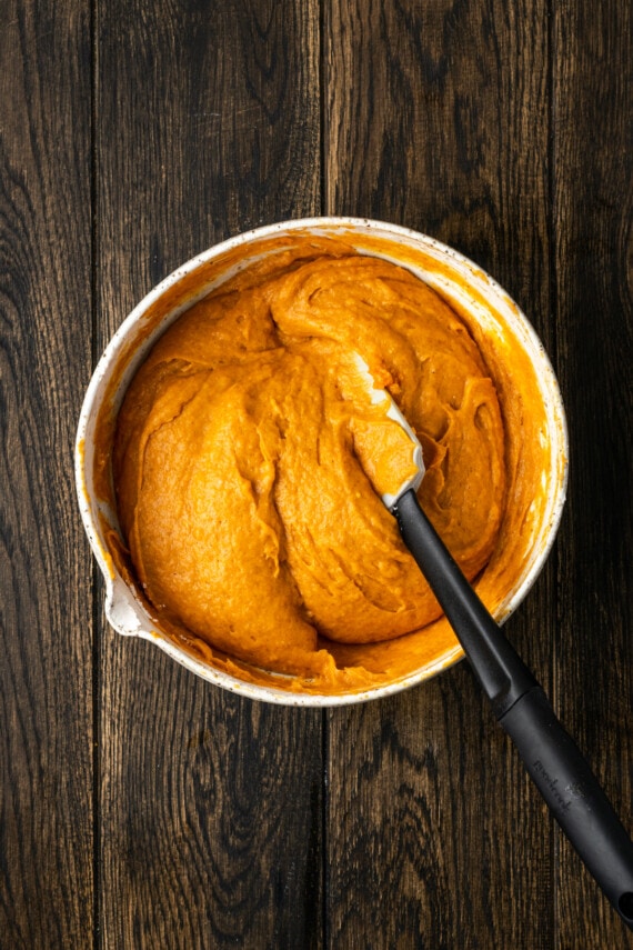 These soft and fluffy pumpkin cookies with cake mix are an easy fall dessert, made with only 2 ingredients and ready for the oven in minutes! Cake mix pumpkin cookie dough combined in a mixing bowl with a spatula.